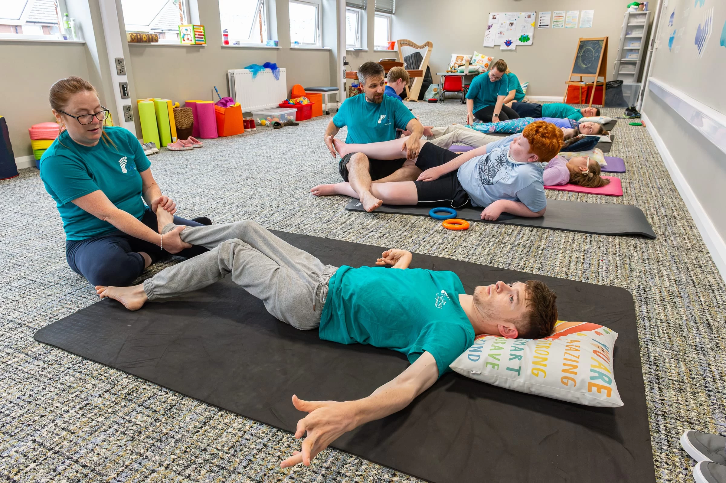 A wide view of the senior group session, with several therapists and young people working in parallel