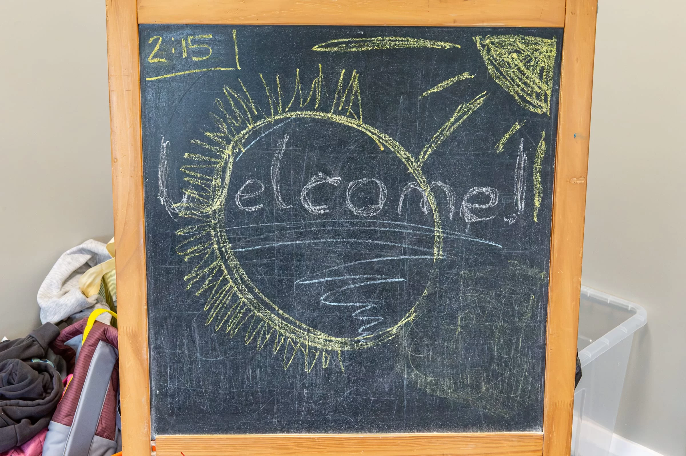 A chalkboard in the therapy room with 'Welcome!' drawn on it in coloured chalk